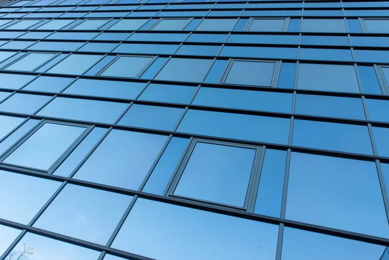 Blau spiegelnde Glasfassade eines modernen Bürogebäudes